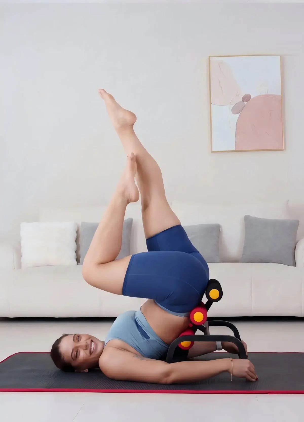 A person with shoulders and head resting on the mat, hips raised on the Magic BB frame, legs lifted in the air