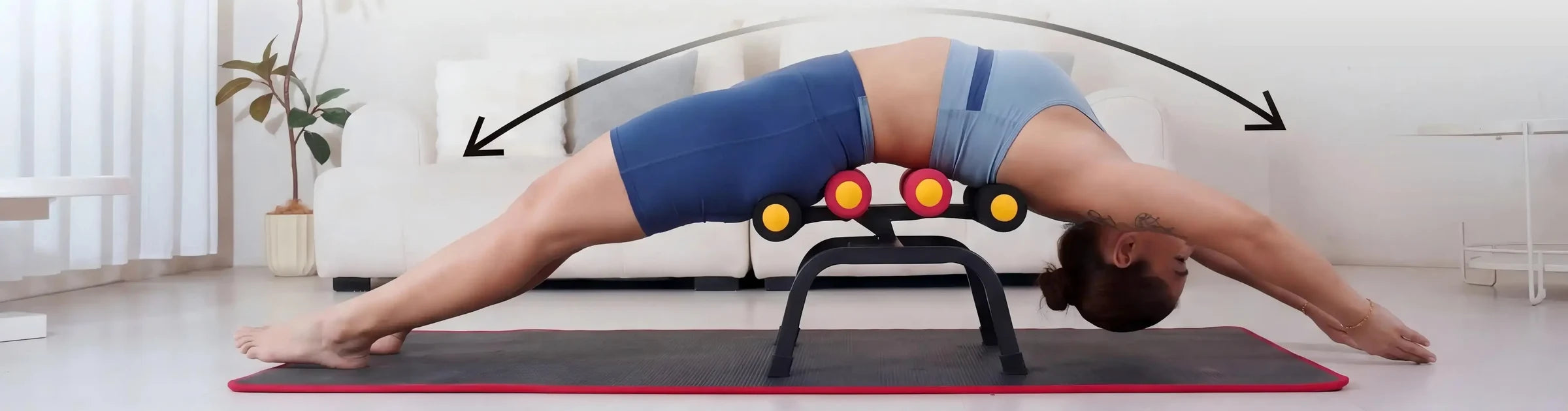 A person lying back over the Magic BB frame in a full-body stretch on a mat, arms reaching overhead